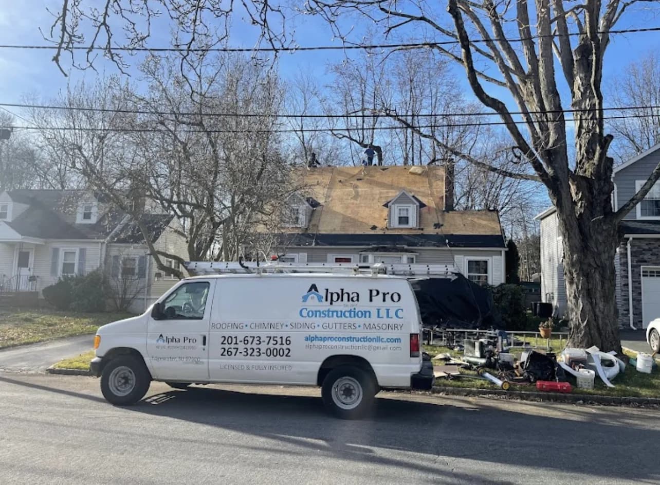 Alpha Pro Construction van parked at a residential roof tear-off jobsite in New Jersey