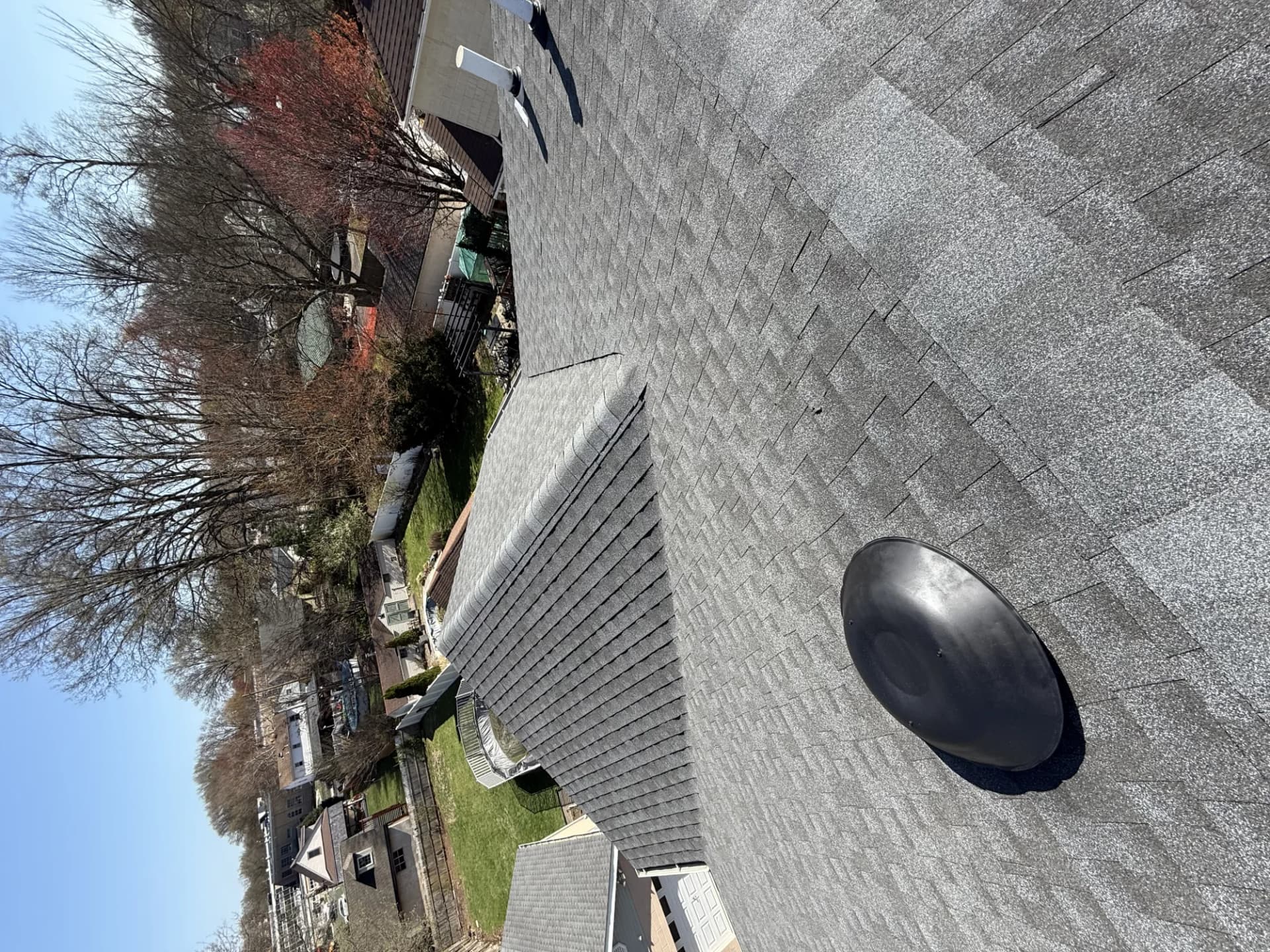 Charcoal asphalt shingle roof with a black pipe boot vent on a completed New Jersey roof