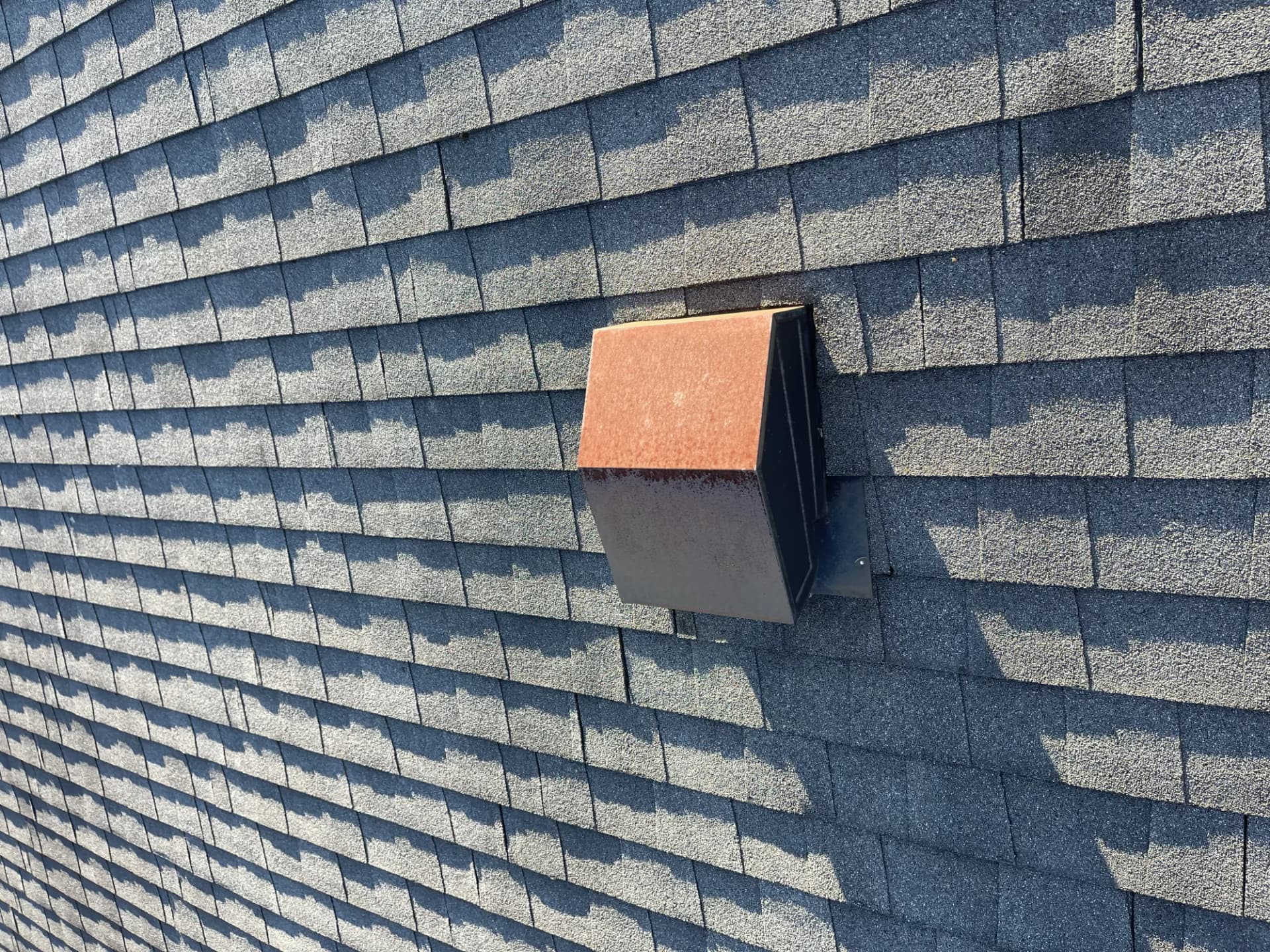 Exhaust vent cap with rust marks on a charcoal asphalt shingle roof requiring repair in New Jersey