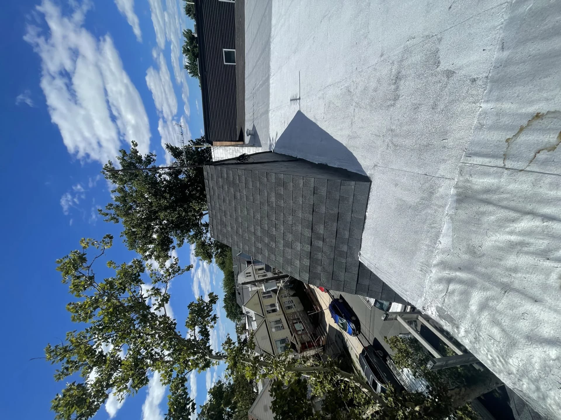 White TPO membrane roof section adjoining an asphalt shingle roof section on a commercial building in New Jersey