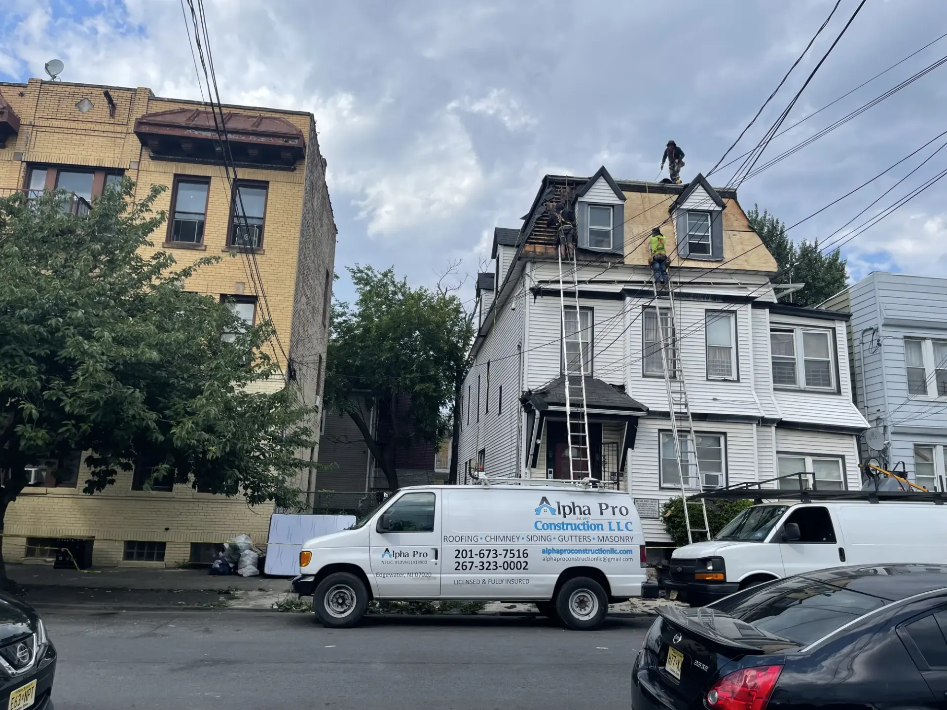 Alpha Pro Construction crew replacing a roof on an urban row home in New Jersey