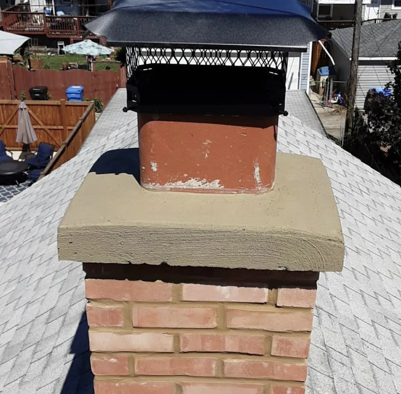 Brick chimney with damaged crown and cap in New Jersey requiring repair before the winter heating season