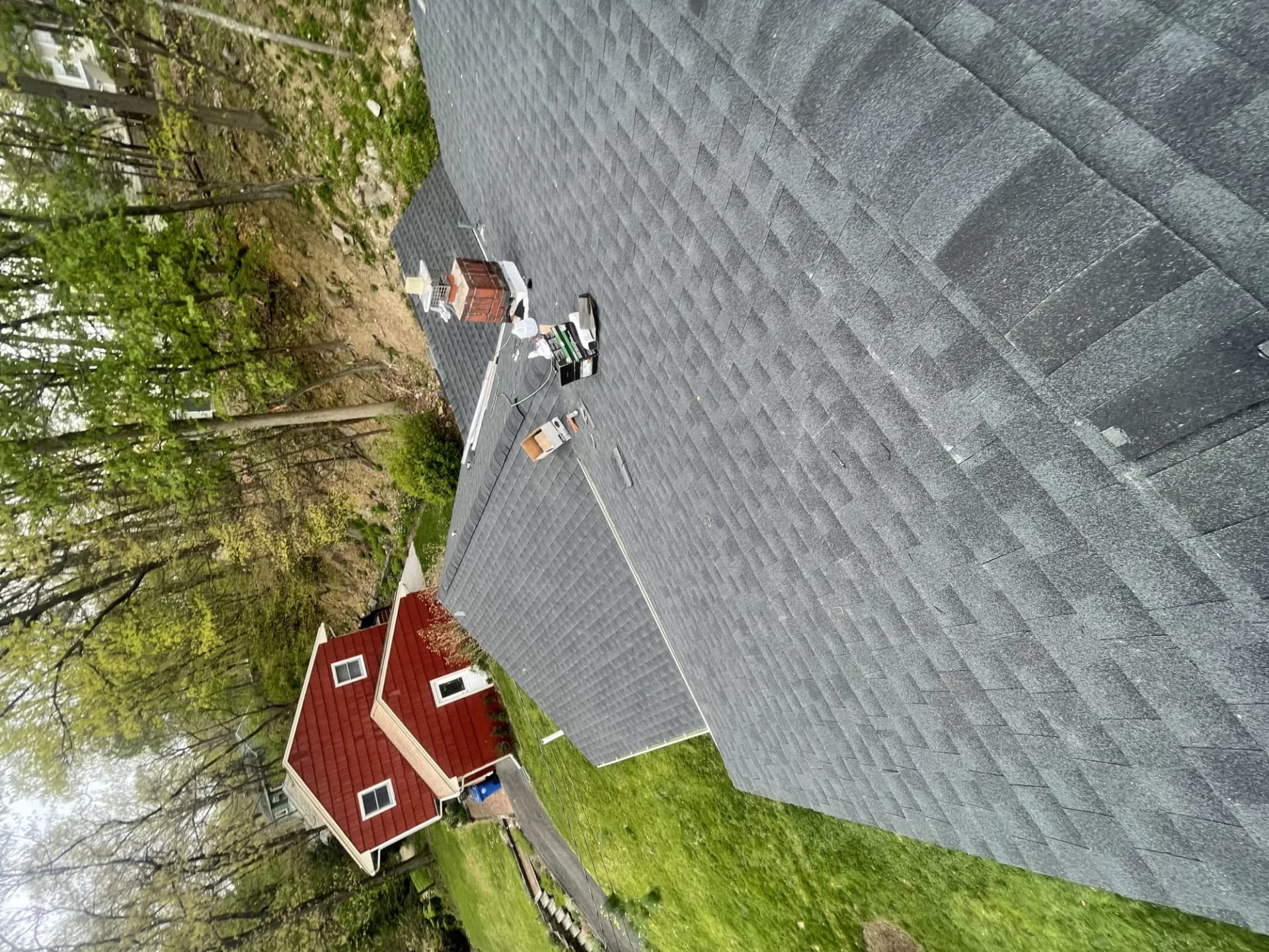 Aerial drone view of a newly installed charcoal gray asphalt shingle roof on a large home in New Jersey